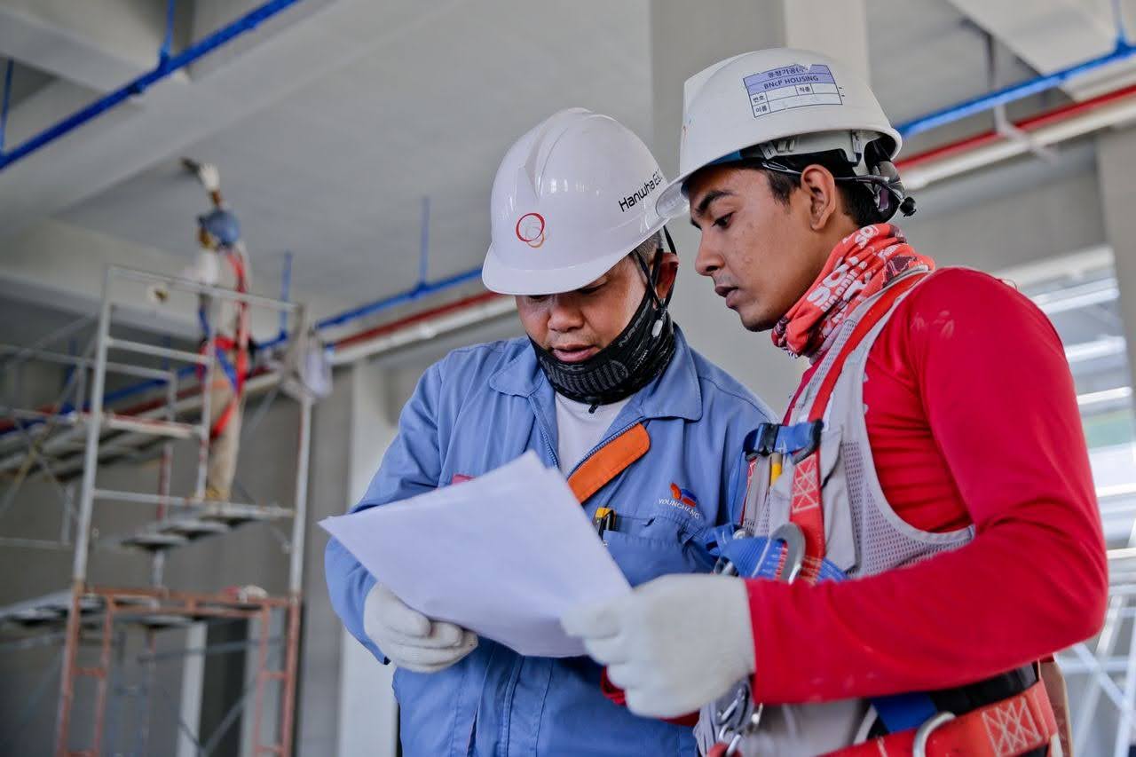 2 orang sedang berunding dalam sebuah proyek konstruksi